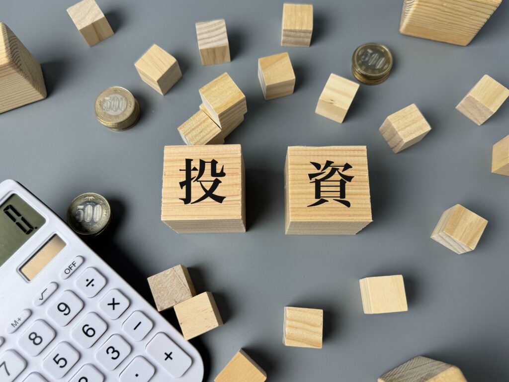 投資・資金調達をイメージした木製ブロックと電卓、公的活動・専門家派遣のイメージ